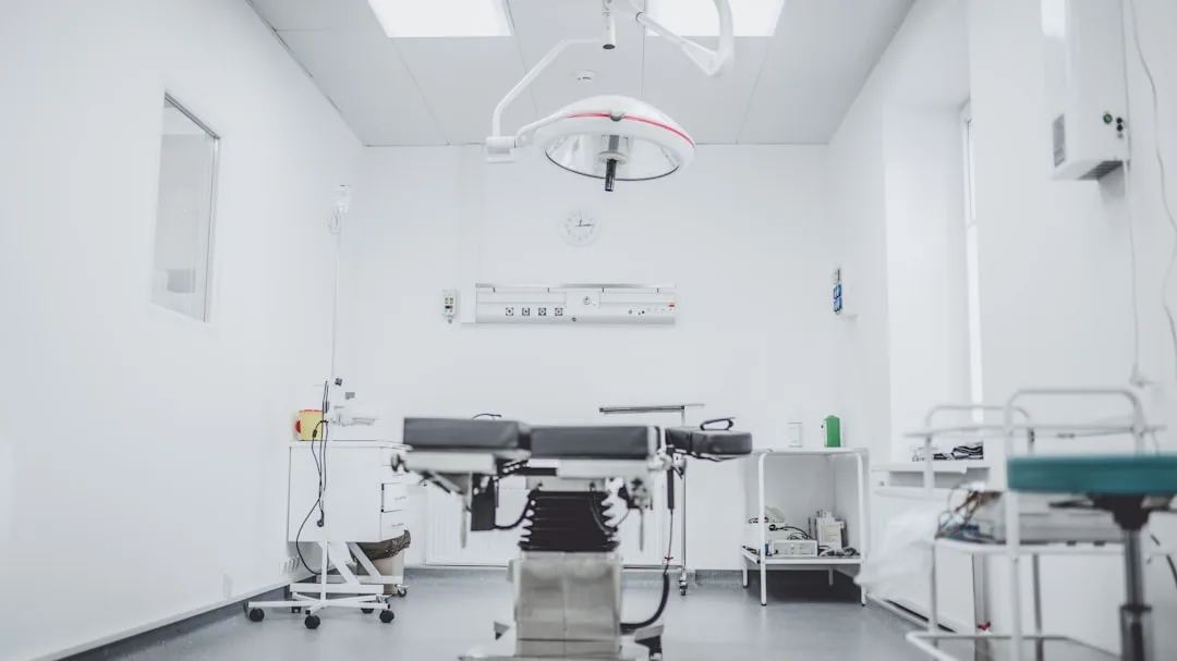 An operating room with a surgical table, overhead light, and medical equipment