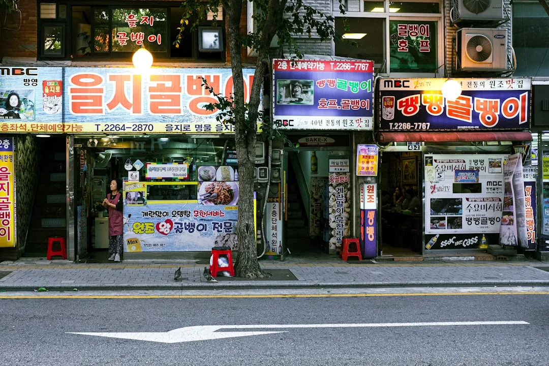 A street scene with a store front and a car parked on the side of the